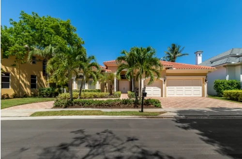 Outside of Florida home, featured with palm trees in front.